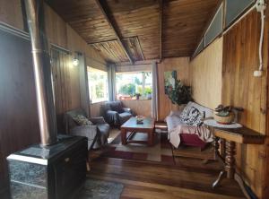 ein Wohnzimmer mit Holzvertäfelung und einem Holzofen in der Unterkunft Cabana El Sauce in San Patricio
