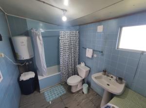 a blue bathroom with a toilet and a sink at Cabana El Sauce in San Patricio