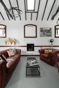 a living room with two leather couches and a fireplace at The El Paso in El Paso