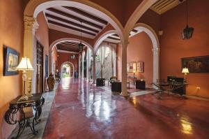 a large room with a hallway with tables and chairs at Hotel Hacienda Mérida VIP in Mérida