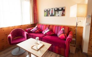 ein Wohnzimmer mit einem roten Sofa und einem Tisch in der Unterkunft Sylvana's Wohlfühl Hotel in Mayrhofen