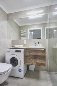 a bathroom with a washing machine and a sink at Apartamenty Świnoujście - Seaside Garden in Świnoujście