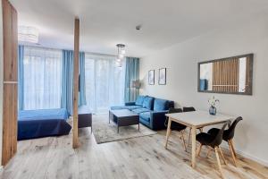 un soggiorno con divano blu e tavolo di Apartamenty Świnoujście - Seaside Garden a Świnoujście