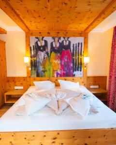 Bett in einem Zimmer mit Wandgemälde in der Unterkunft Sylvana's Wohlfühl Hotel in Mayrhofen