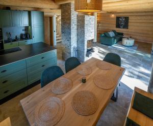 a kitchen and dining room with a wooden table and chairs at Chalet NON-SENS by L'Occitane in Hochrindl