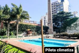 una piscina con parque infantil frente a un edificio en Moderno Loft en Palermo Queen. en Buenos Aires