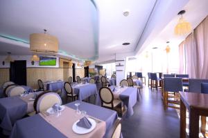 Sky Boutique Ennahda Rennaissance في مراكش: غرفة طعام مع طاولات وكراسي بيضاء