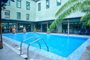 a large swimming pool in front of a building at Harbour View Suites in Dar es Salaam