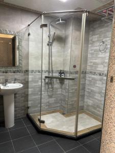 a shower with a glass door in a bathroom at Yiren Hotel in Hengchun