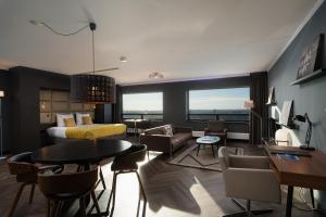 um quarto de hotel com uma cama, uma mesa e cadeiras em The Penthouse At The Hague Tower em Haia