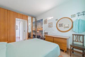 um quarto com uma cama, uma secretária e um espelho em L'Albero del Pepe 1 - Goelba em Campo nell'Elba