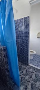 a bathroom with a shower with a blue shower curtain at Playa El Obispo D La Marea building La Libertad in La Libertad