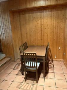 un tavolo con sedie in una stanza con pareti in legno di Sierra Nevada Estudio Luminoso Urb Los Valles a Monachil