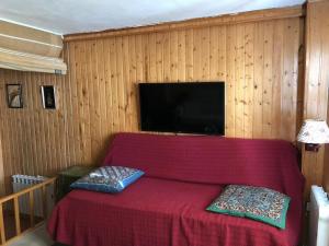 a bedroom with a red bed with two pillows on it at Sierra Nevada Estudio Luminoso Urb Los Valles in Monachil +7 photos