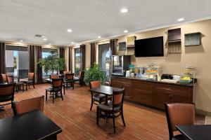 a dining room with tables and chairs and a television at Quality Inn in Dandridge