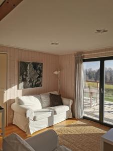 a living room with a white couch and a window at Le Chalet du Tchession in Malmedy