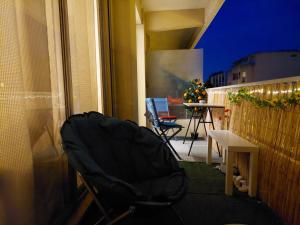 a balcony with a chair and a table with a christmas tree at Studio 30 m2 cocooning Timone Marseille in Marseille