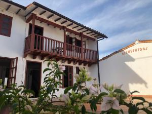 ein weißes Gebäude mit einem Balkon und Blumen in der Unterkunft Rustico Hostel Barichara in Barichara