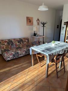 uma sala de estar com uma mesa e um sofá em Appartamento in Franciacorta vicino al Lago Iseo em Corte Franca
