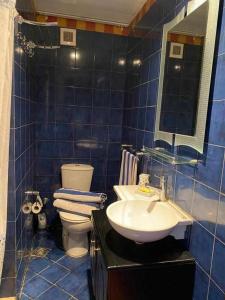 a blue tiled bathroom with a sink and a toilet at Porto marina for rent in El Alamein