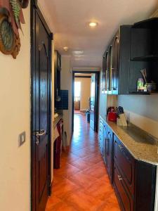 a kitchen with black cabinets and a tile floor at Porto marina for rent in El Alamein