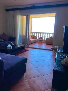 a living room with a couch and a large window at Porto marina for rent in El Alamein