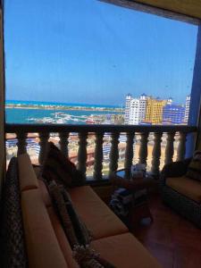 a living room with a view of the ocean from a balcony at Porto marina for rent in El Alamein