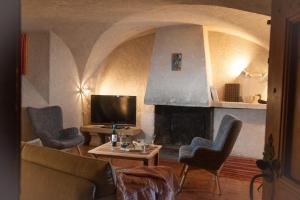 a living room with a tv and a fireplace at Maison traditionnelle briançonnaise in Briançon