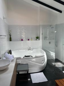 uma casa de banho branca com uma banheira e um lavatório em Hotel Villa Teresita em Sáchica