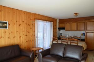 a living room with a couch and a kitchen at Immeuble Les Sérandes in Les Collons