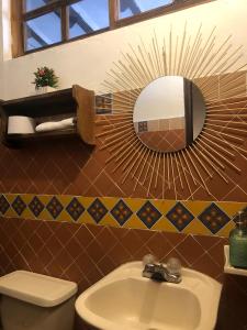 baño con lavabo y espejo en la pared en Rustico Hostel Barichara en Barichara