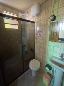 a bathroom with a shower and a toilet and a sink at Flat Maricá com ar-condicionado in Maricá