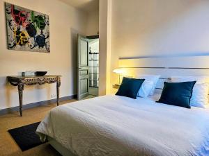 sypialnia z łóżkiem z niebieskimi poduszkami i stołem w obiekcie L'Idrac, Appartements en Hyper centre w Tuluzie