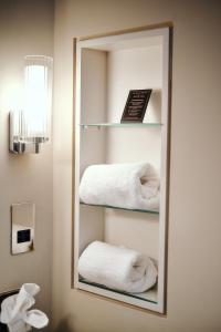 a mirror in a bathroom with towels at The Black Lion Pub & Boutique Guesthouse in London