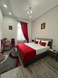ein Schlafzimmer mit einem großen Bett mit einer roten Decke in der Unterkunft Hotel Fleur Yerevan in Yerevan