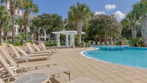 a group of lounge chairs next to a swimming pool at Le Jardin 168 - 3BR 3.5BA - (10) in Destin