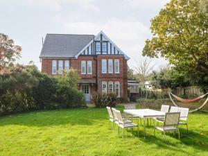 a house with a table and chairs in the yard at 5 The Nab House in Bembridge