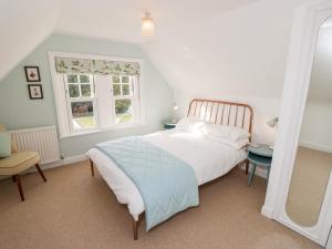 a bedroom with a bed and a table and a window at 5 The Nab House in Bembridge