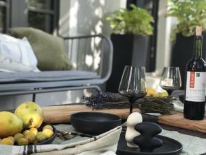 einen Tisch mit zwei Weingläsern und einer Flasche Wein in der Unterkunft Landlust - Landhaus mit Garten in Bergholz