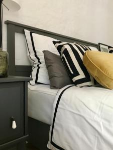 - un lit avec des oreillers en noir et blanc dans l'établissement Landlust - Landhaus mit Garten, à Bergholz