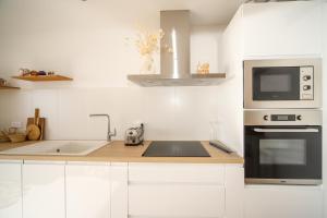 a white kitchen with a sink and a microwave at T3 Octopus VUE MER Palavas in Palavas-les-Flots