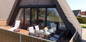 Un patio con una mesa y sillas en una terraza. en Nurdachhaus PIRATEN LOUNGE, en Butjadingen