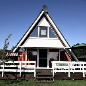 a house with a gambrel roof with a porch at Nurdachhaus PIRATENWEG 131 in Butjadingen