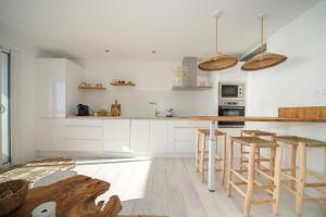 a kitchen with white cabinets and a counter with stools at T3 Octopus VUE MER Palavas in Palavas-les-Flots