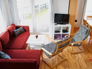 a living room with a red couch and chairs at FLOATING HOUSES - "schwimmende Ferienhäuser" - Haus 5 in Barth