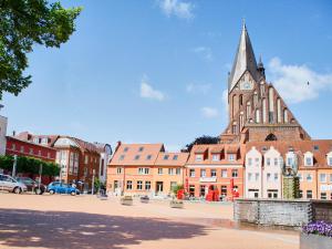 a building with a clock tower in a city at FLOATING HOUSES - "schwimmende Ferienhäuser" - Haus 5 in Barth