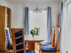 a dining room table with blue chairs and a window at FLOATING HOUSES - "schwimmende Ferienhäuser" - Haus 5 in Barth