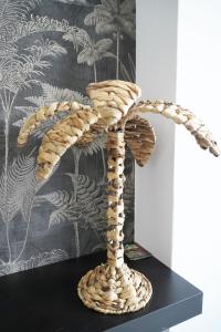 a wooden sculpture of a palm tree on a black table at Vista taurito Ely in Taurito