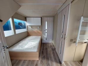 ein kleines Zimmer mit einem Bett und zwei Fenstern in der Unterkunft Floating 33 - LEA SOPHIE in Marienfelde