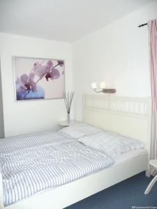 een slaapkamer met een bed en een schilderij aan de muur bij FLOATING HOUSES Comfort - "Schwimmende Ferienhäuser" - Haus 7 in Kröslin